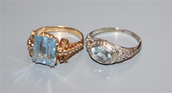 A 14k white metal and aquamarine ring and a 750 yellow metal and synthetic spinel? ring.